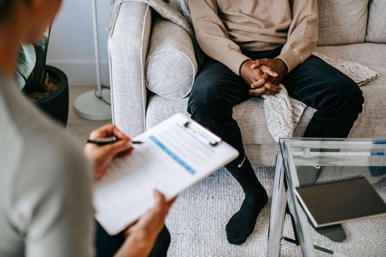 Doctor taking notes while a patient shares concerns during a psychiatric consultation