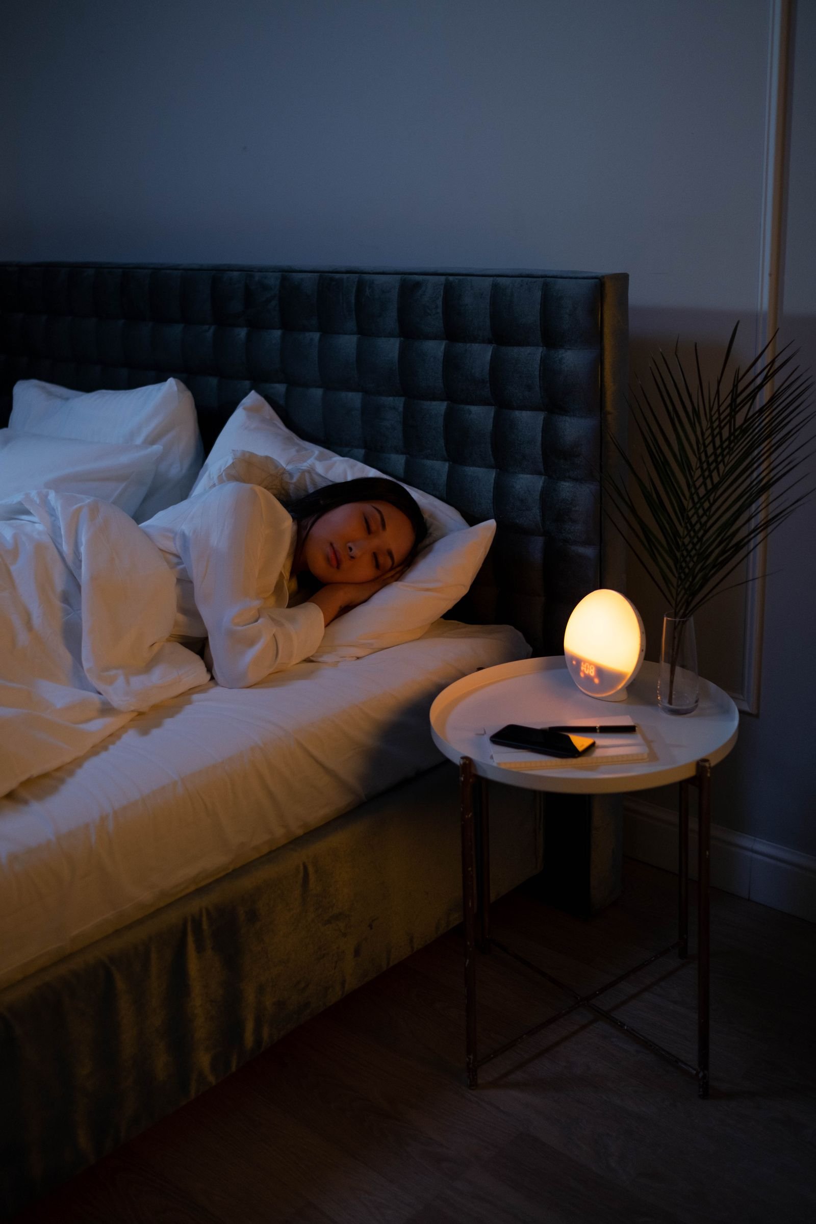 Patient sleeping peacefully in a dim bedroom lit by a warm bedside lamp