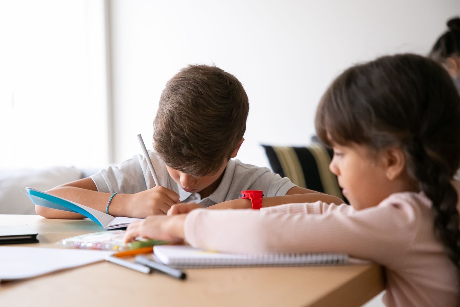 Child concentrating on writing at a desk — paediatric neurological and developmental assessment